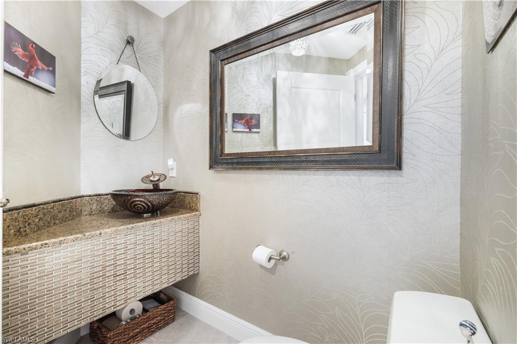 Bathroom with wallpapered walls and vanity