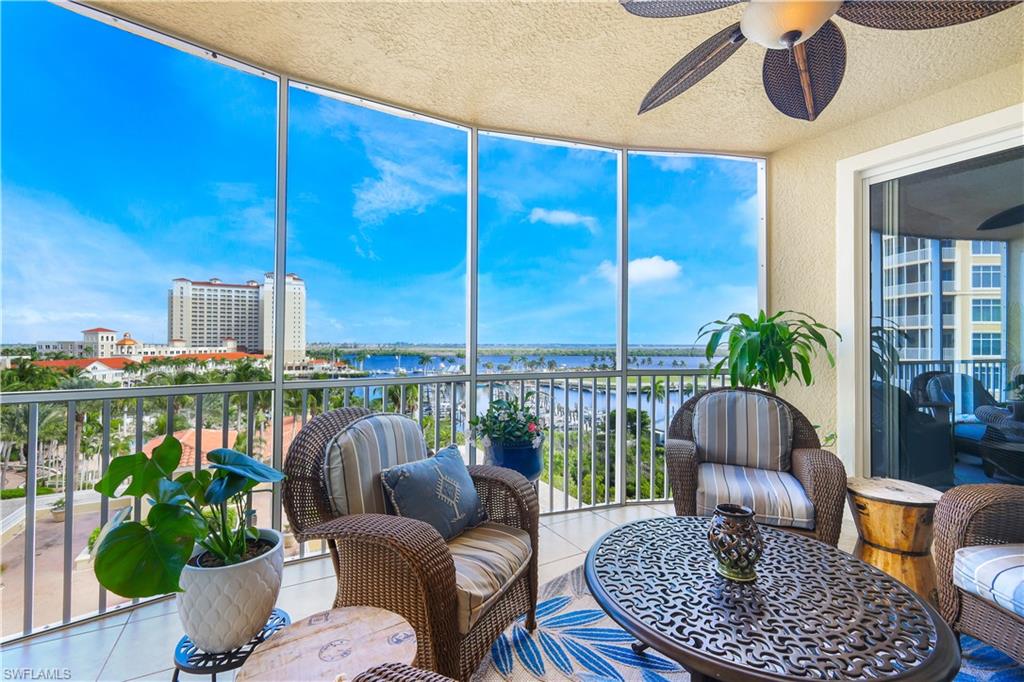 Sunroom featuring a wall of windows, a water view, tile patterned floors, a textured ceiling, and a textured wall