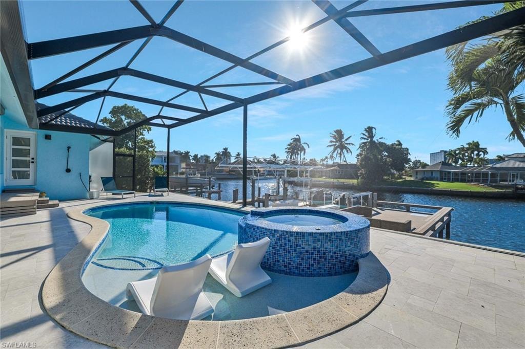 View of swimming pool featuring a patio area, a sunroom, boat lift, and a boat dock