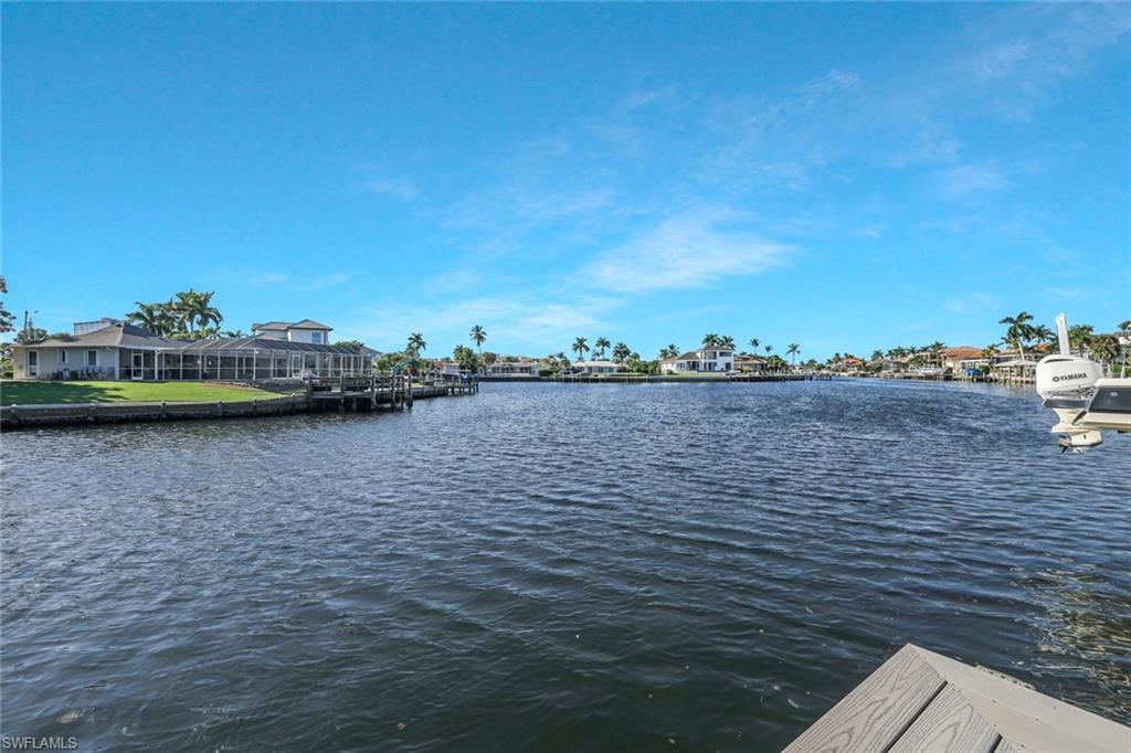 Water view featuring nearby suburban area and a boat dock
