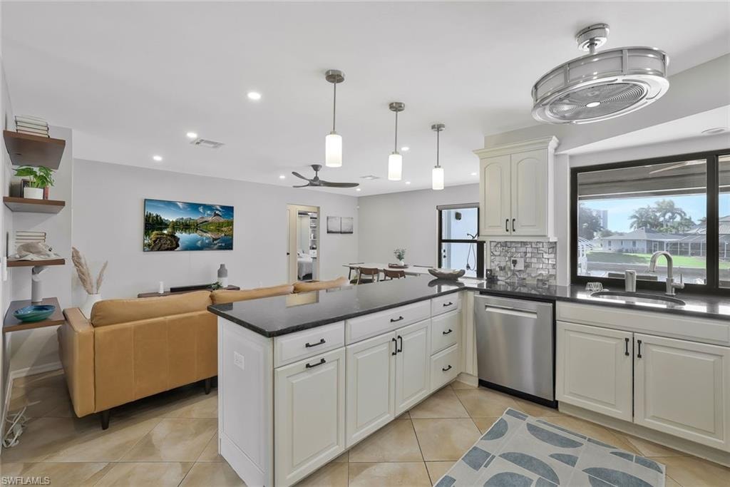Kitchen featuring ceiling fan, dishwasher, decorative backsplash, light tile patterned floors, and decorative light fixtures