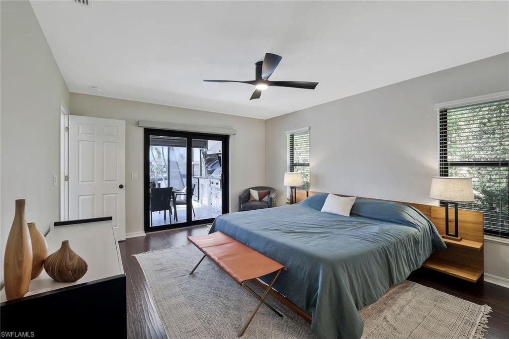 Bedroom with dark wood finished floors, access to outside, and a ceiling fan