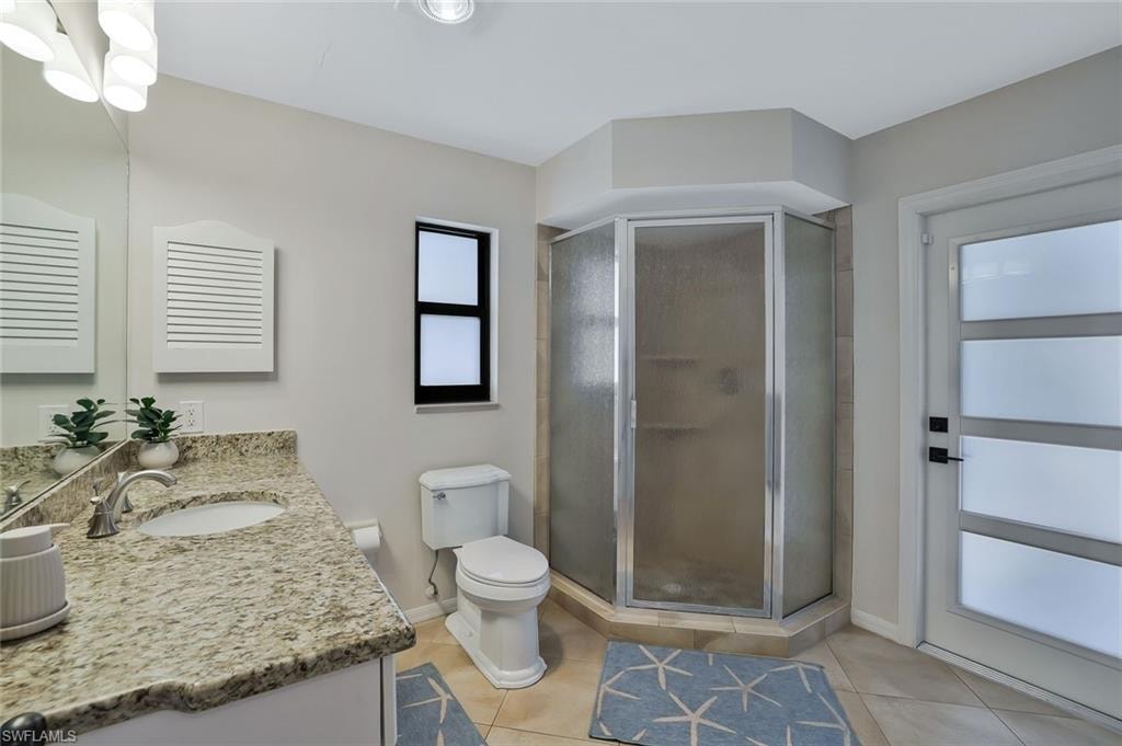 Bathroom featuring vanity, a shower stall, and light tile patterned flooring