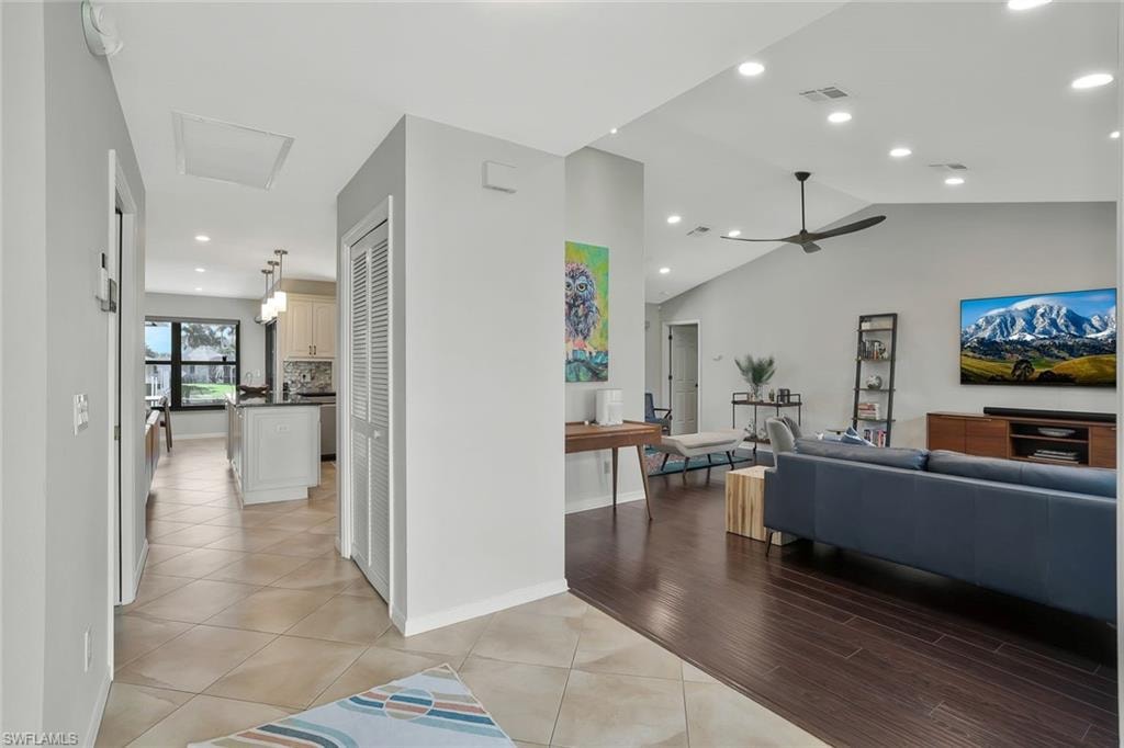 Living area with recessed lighting, vaulted ceiling, light tile patterned floors, and ceiling fan
