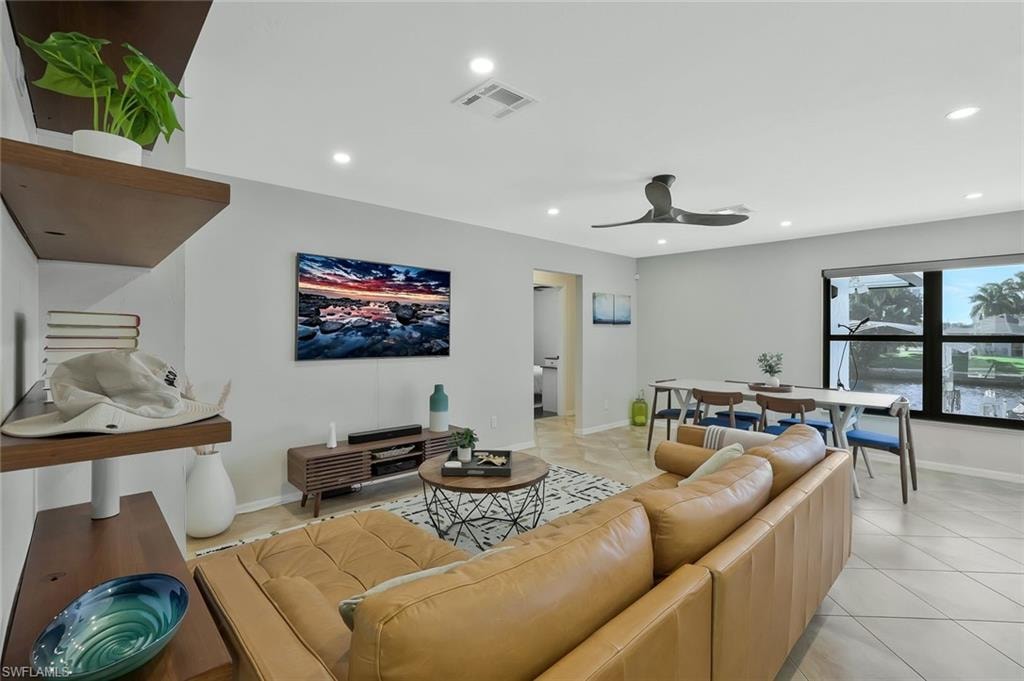 Living area with light tile patterned flooring, a ceiling fan, and recessed lighting