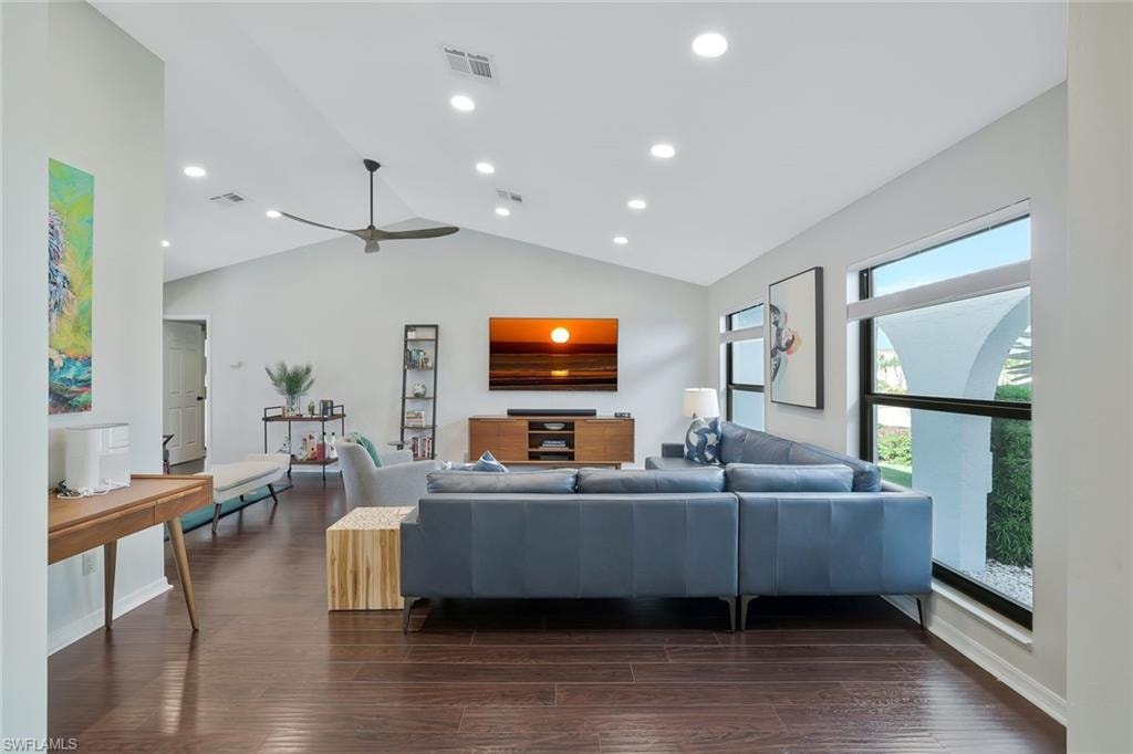 Living room with dark wood finished floors, ceiling fan, recessed lighting, and high vaulted ceiling