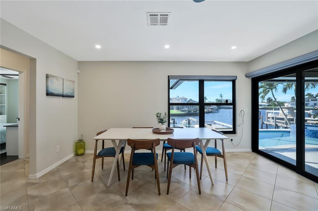 Dining area featuring a water view, recessed lighting, and light tile patterned floors