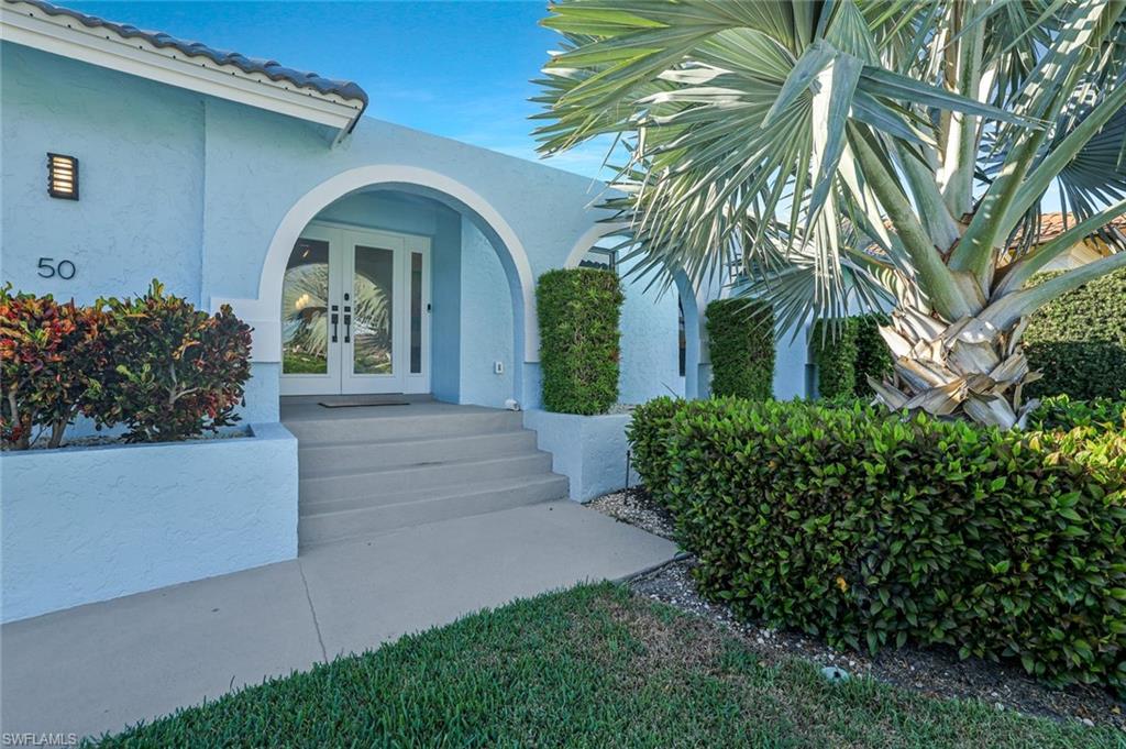 View of exterior entry featuring french doors, stucco siding, and a tile roof