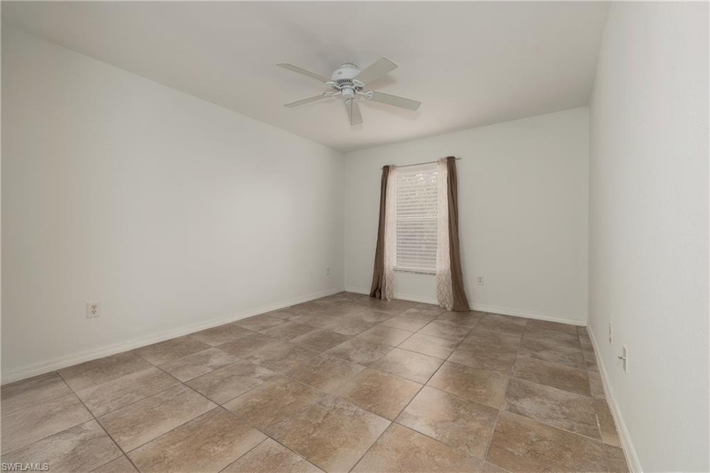 Empty room featuring baseboards and ceiling fan