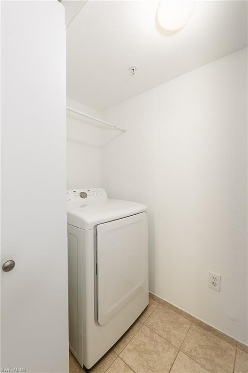 Washroom featuring washer / dryer and light tile patterned floors