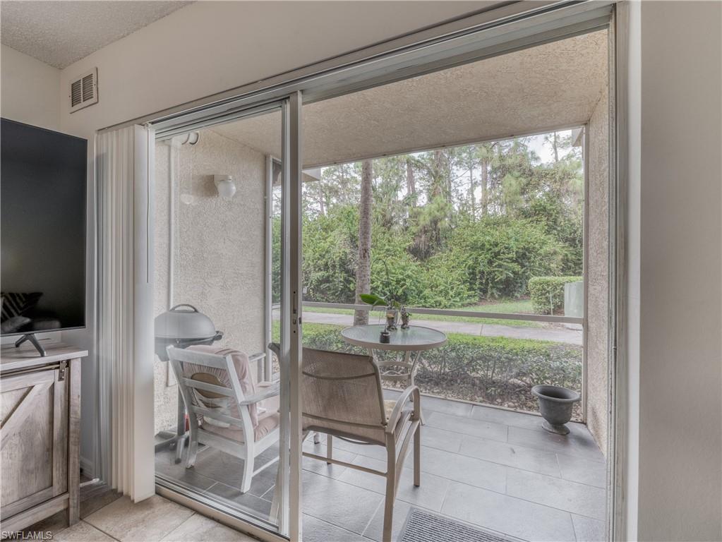 Sunroom / solarium featuring view of wooded area