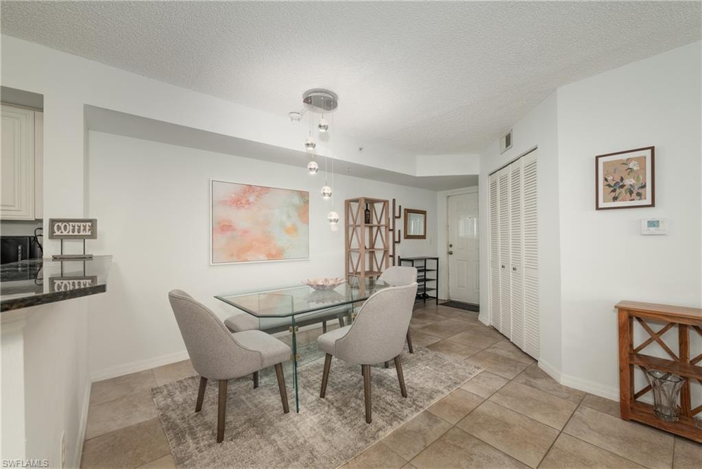 Dining space featuring a textured ceiling and baseboards