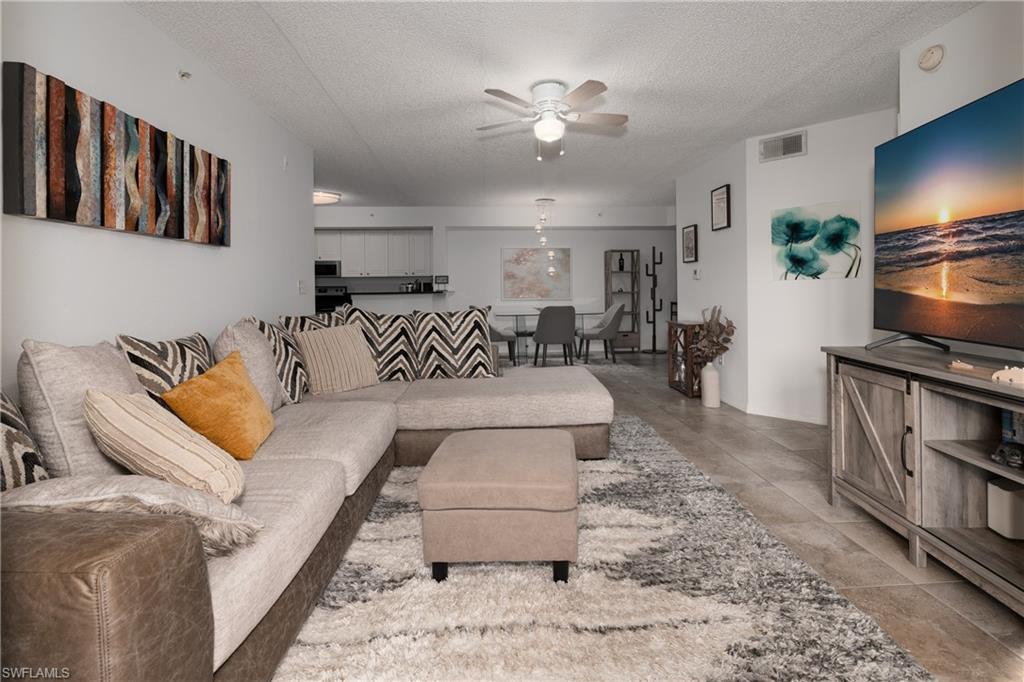 Living room with a textured ceiling and a ceiling fan