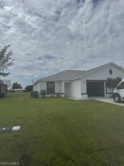 Single story home featuring a front lawn, a garage, driveway, and stucco siding
