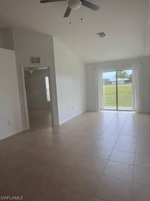 Empty room featuring healthy amount of natural light, light tile patterned floors, a ceiling fan, and lofted ceiling
