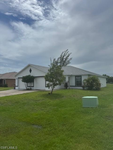 Single story home with concrete driveway, a front yard, an attached garage, and roof with shingles