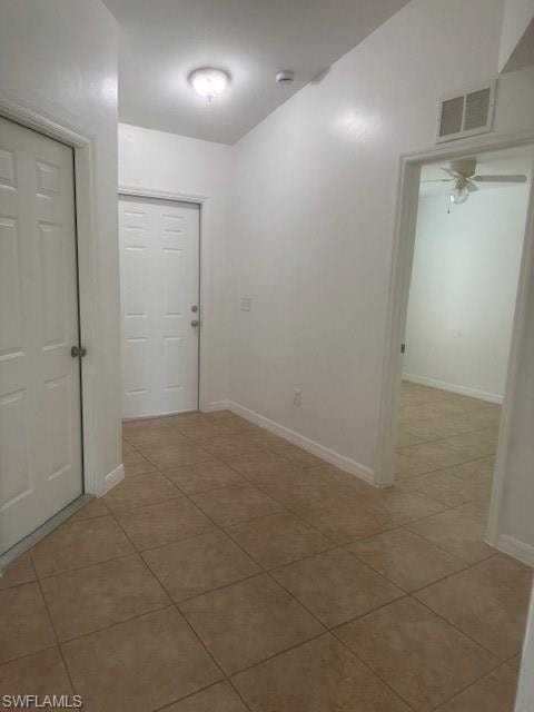 Unfurnished room with light tile patterned floors and a ceiling fan
