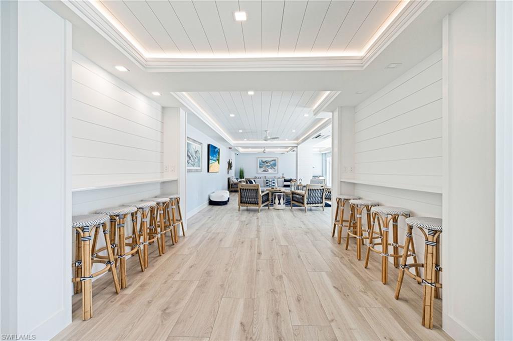 Dining area featuring light wood finished floors, a raised ceiling, recessed lighting, and ornamental molding