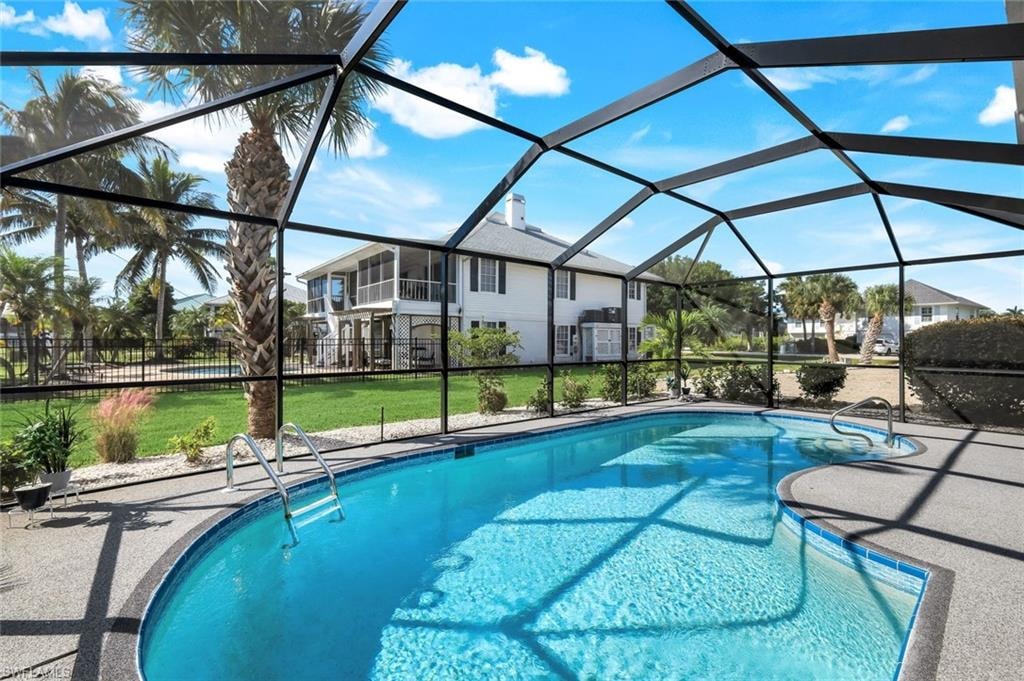 Swimming pool featuring a sunroom, a lanai, and a patio