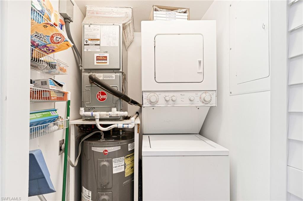 Washroom with water heater, heating unit, and stacked washer / drying machine