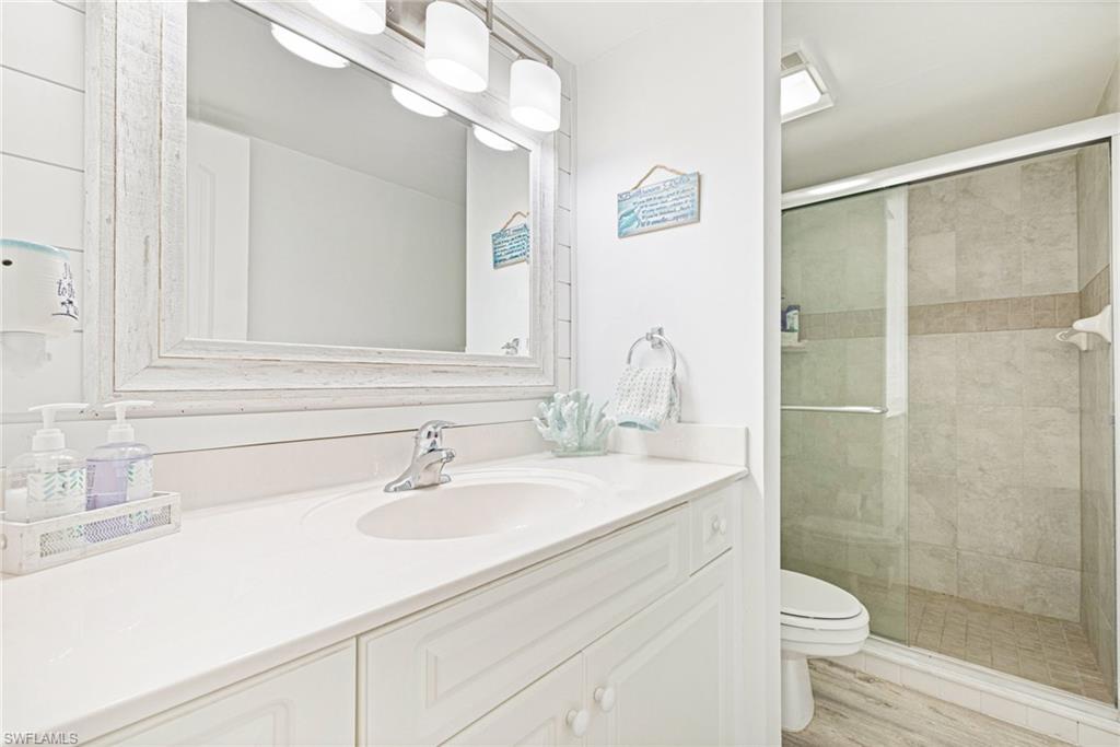 Bathroom featuring vanity, a shower stall, and light wood-type flooring
