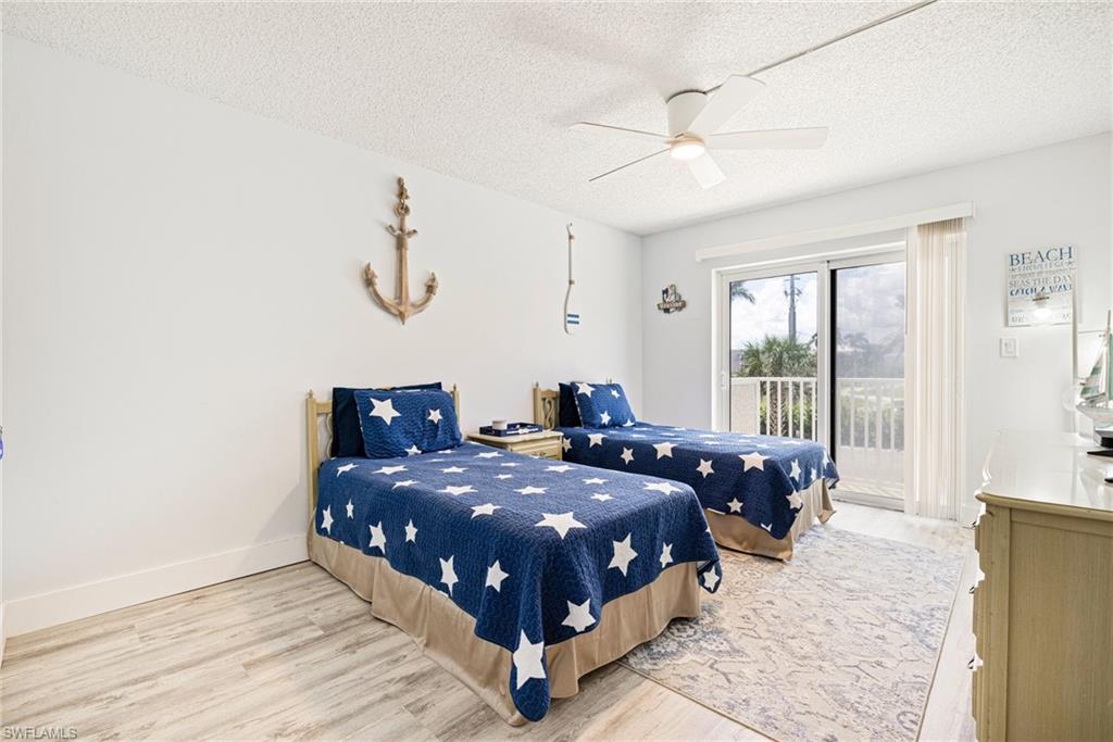 Bedroom featuring light wood-style flooring, a textured ceiling, access to outside, and ceiling fan