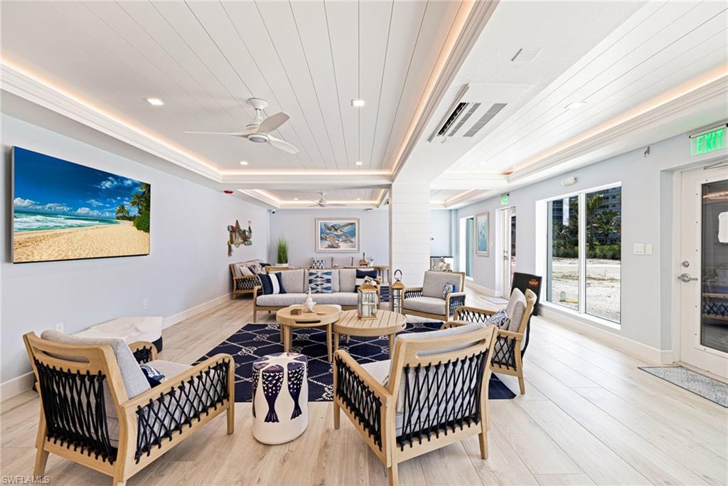 Living area with wooden ceiling, light wood finished floors, a raised ceiling, recessed lighting, and ceiling fan