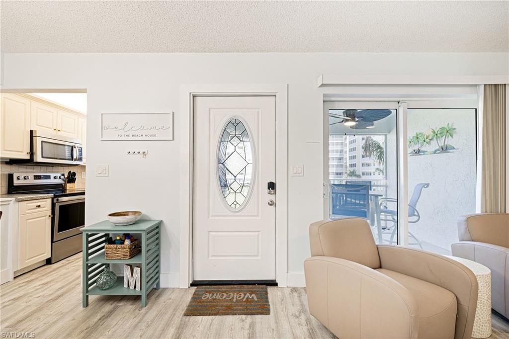 Foyer featuring light wood finished floors, a textured ceiling, and a ceiling fan