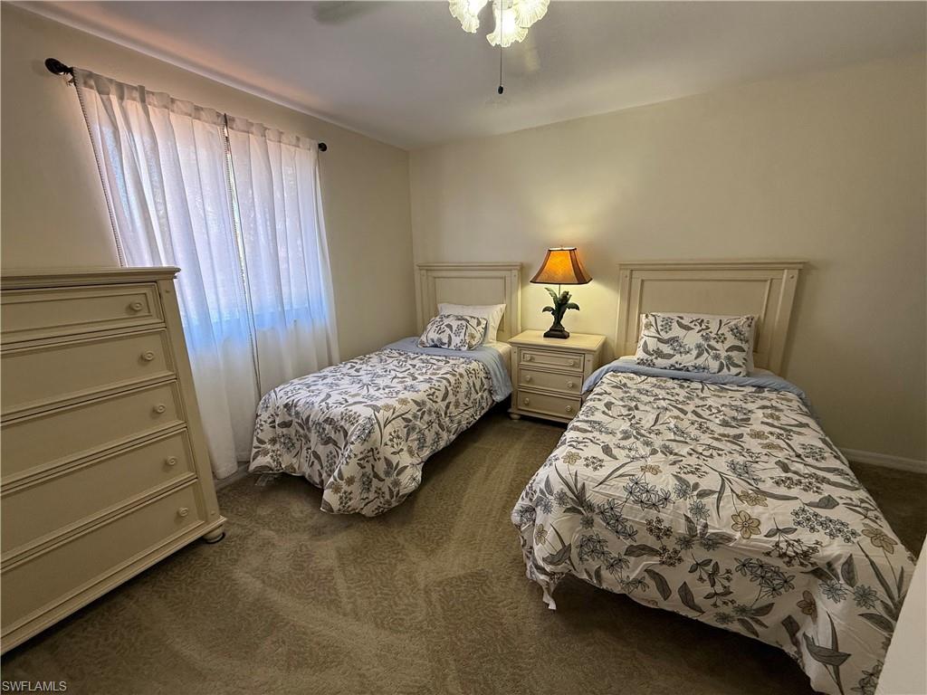 Bedroom featuring dark colored carpet and ceiling fan