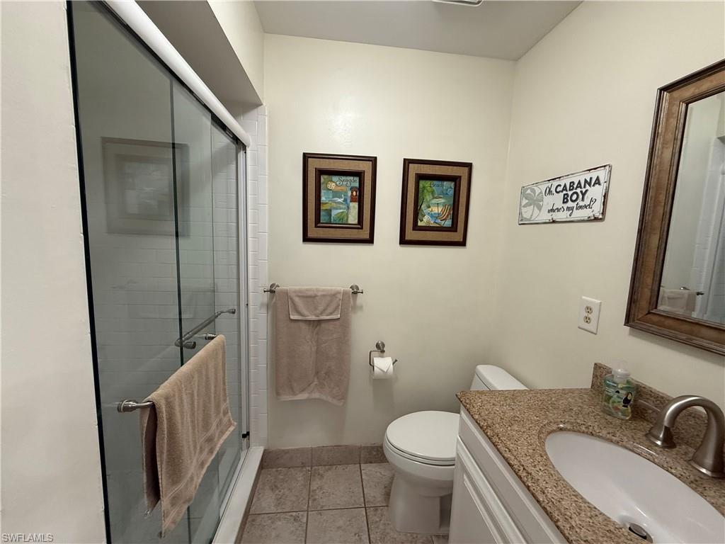 Bathroom with a stall shower, vanity, and light tile patterned floors