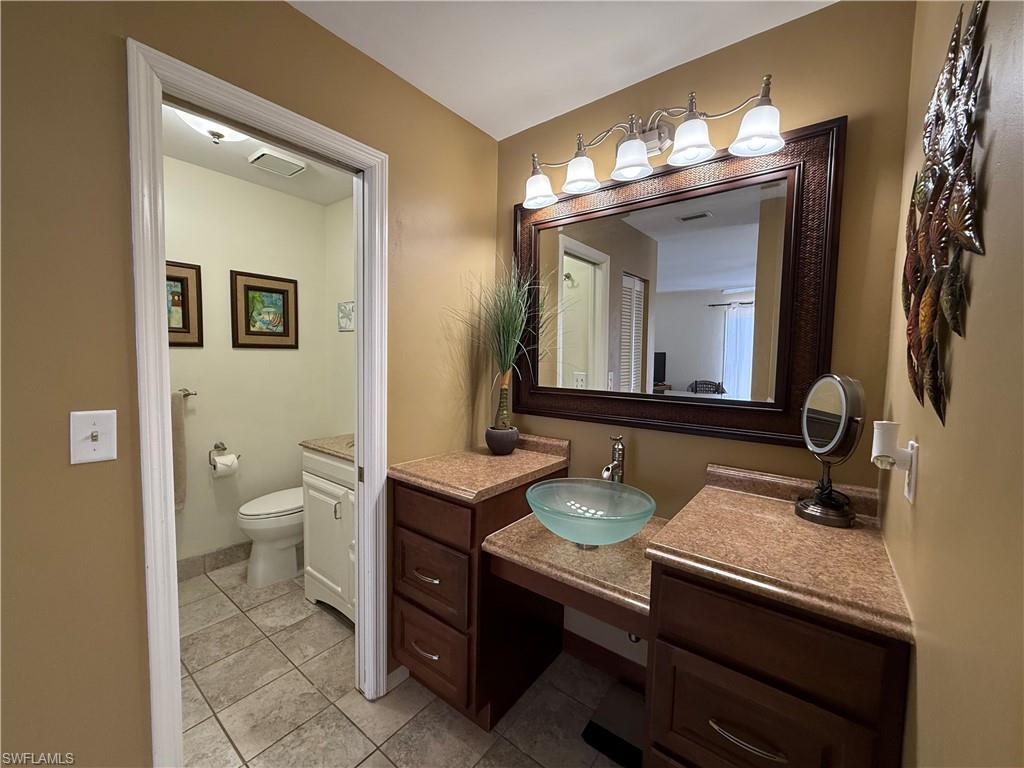 Bathroom with light tile patterned floors and vanity