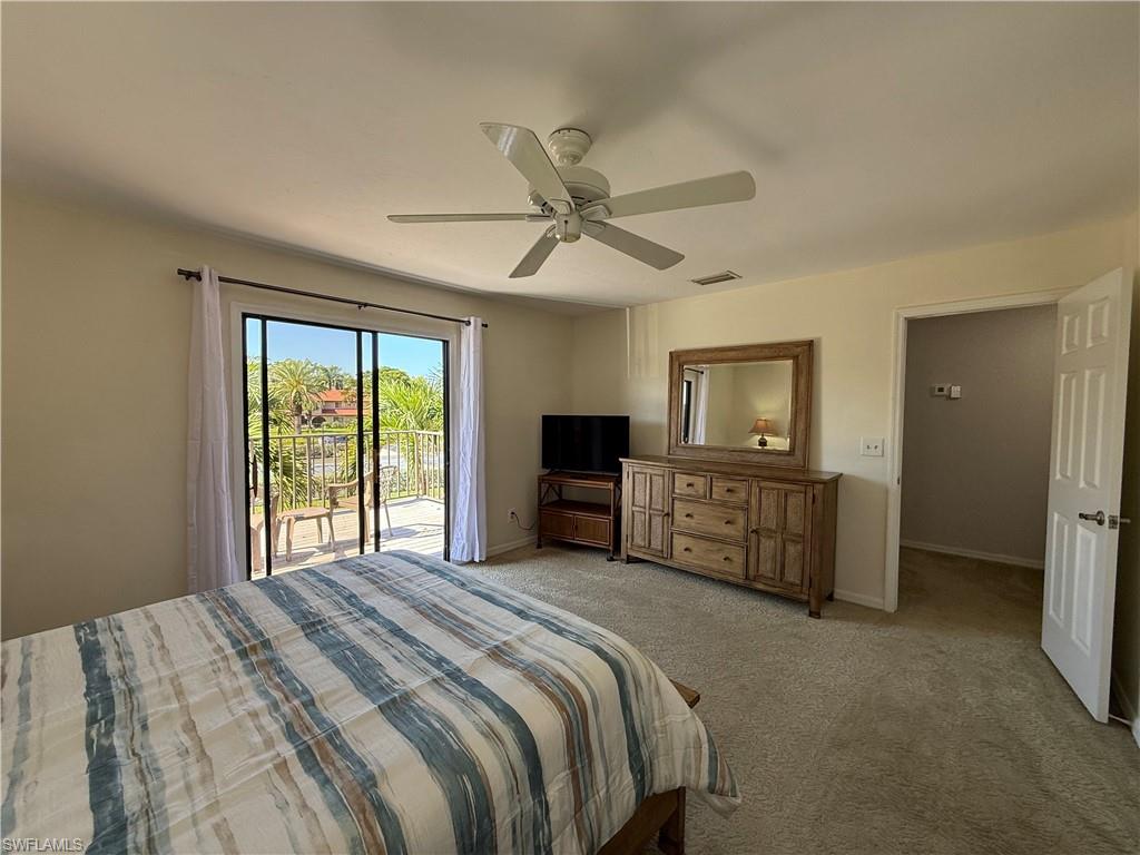 Carpeted bedroom with access to outside and a ceiling fan