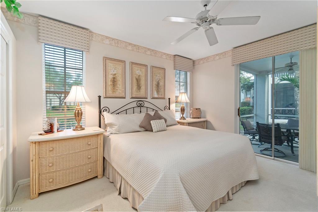 Carpeted bedroom featuring multiple windows, access to exterior, a ceiling fan, and a sunroom