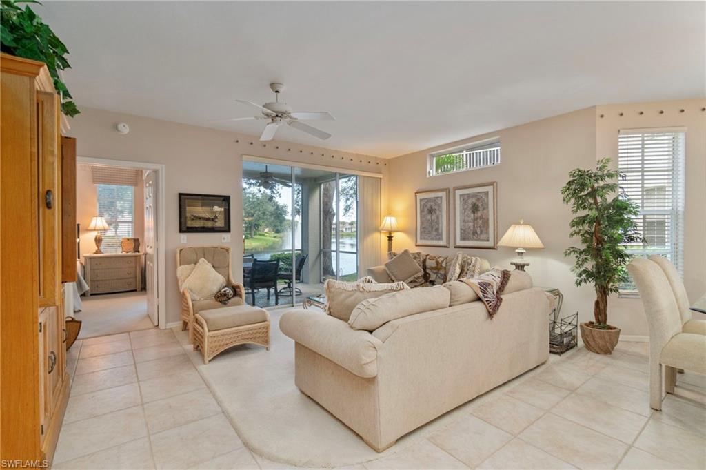 Living room featuring light tile patterned flooring, plenty of natural light, and a ceiling fan