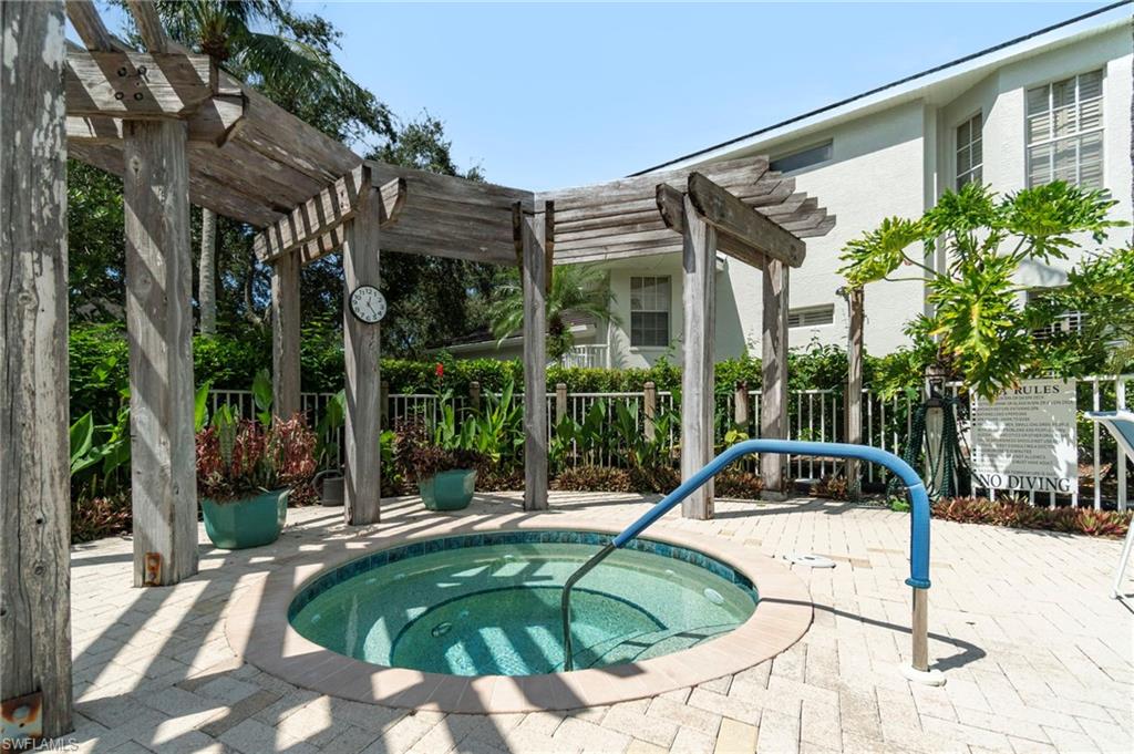 View of swimming pool with a community hot tub, a patio area, and a pergola