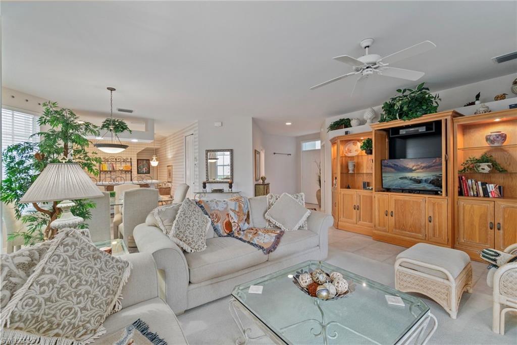 Living room with ceiling fan and light tile patterned flooring