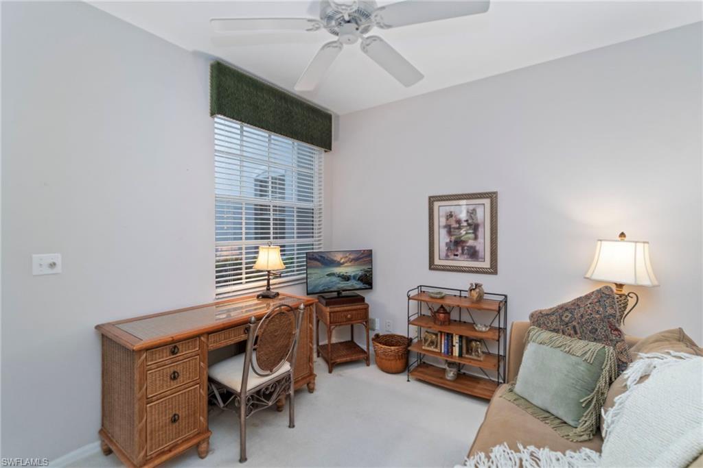 Carpeted office space featuring a ceiling fan