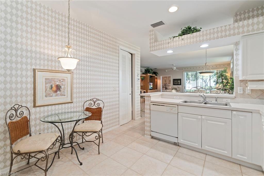 Kitchen with hanging light fixtures, light countertops, dishwasher, white cabinets, and recessed lighting