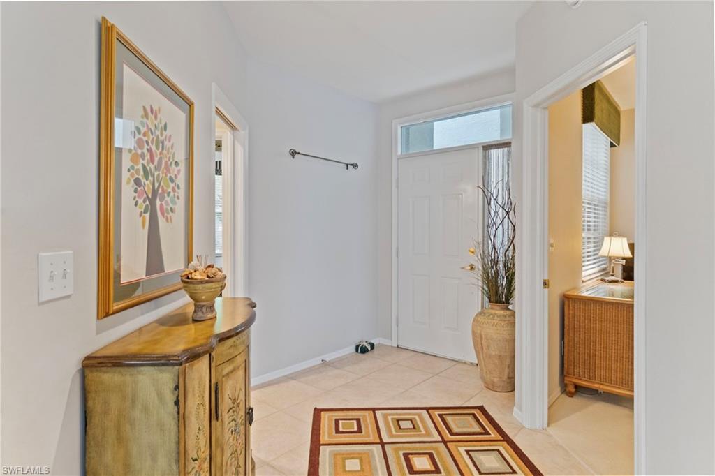 Foyer with baseboards and light tile patterned floors
