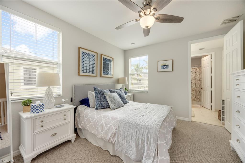 Bedroom with light carpet, a ceiling fan, and ensuite bathroom