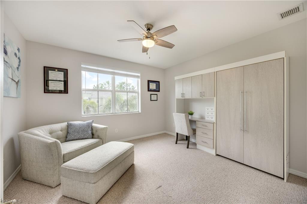 Sitting room featuring light carpet, ceiling fan, and built in study area