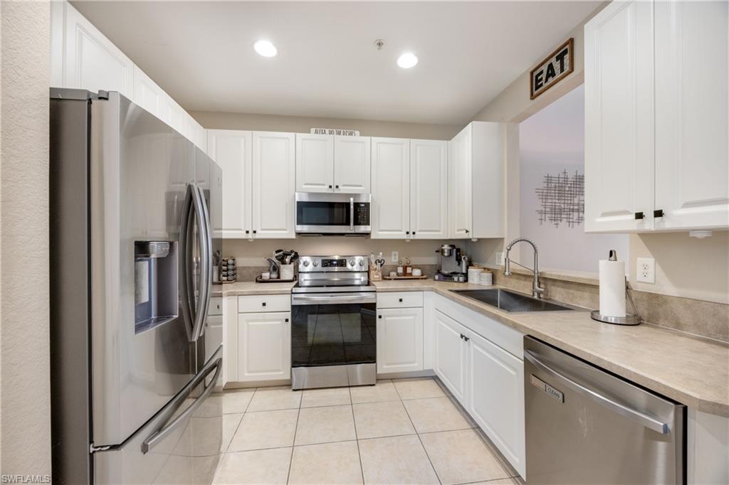 Kitchen featuring stainless steel appliances, light countertops, white cabinetry, recessed lighting, and light tile patterned flooring