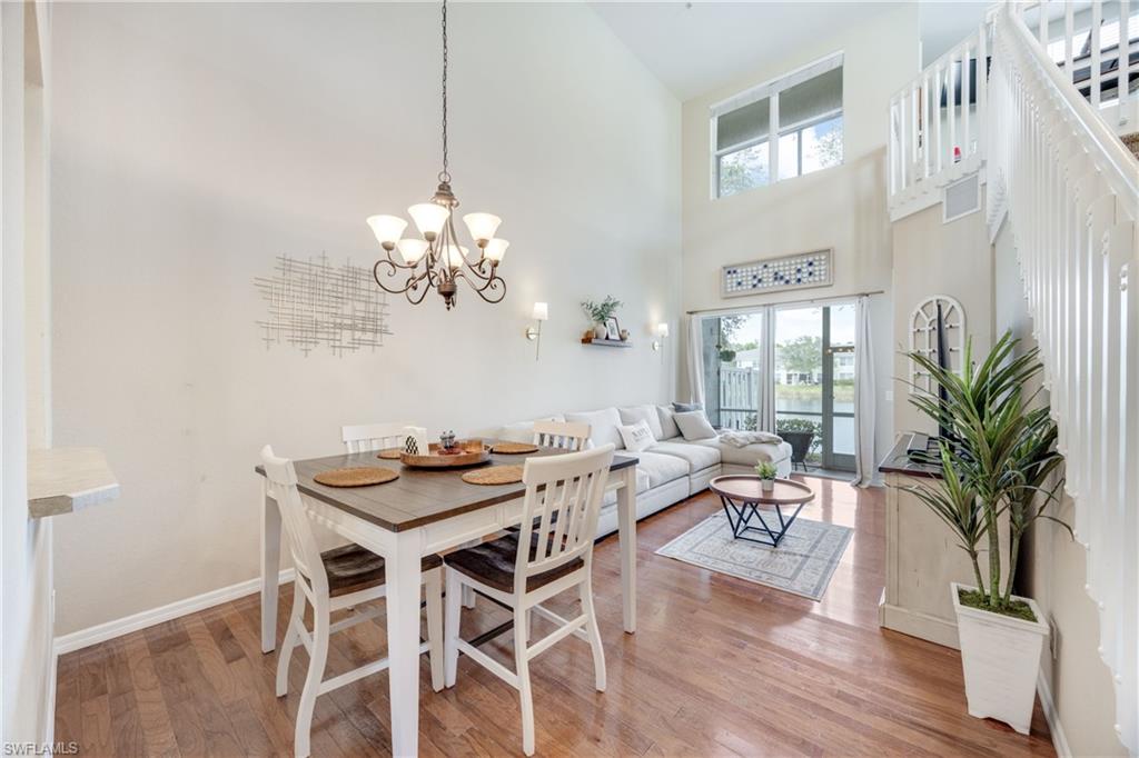 Dining space featuring light wood-style flooring, a high ceiling, and a chandelier