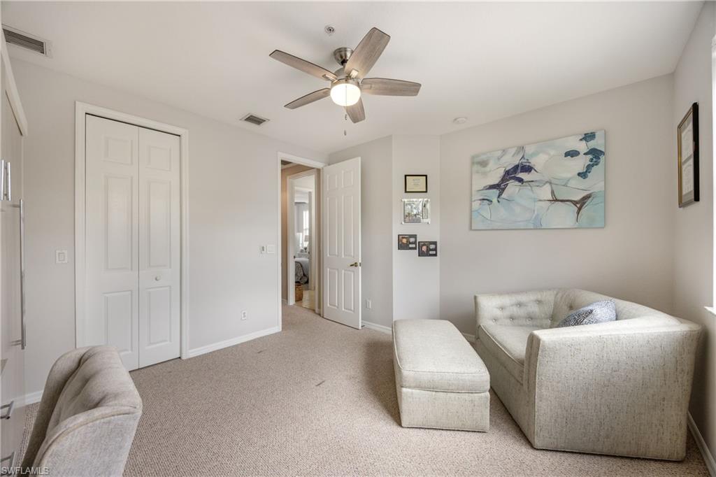 Living area with a ceiling fan and carpet floors