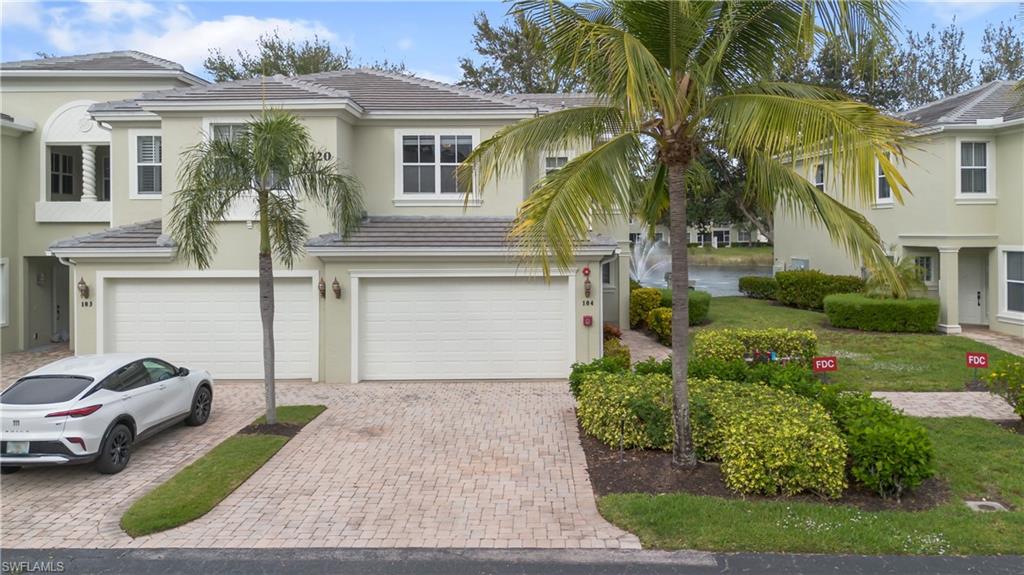View of front of home featuring stucco siding, decorative driveway, an attached garage, and a tile roof