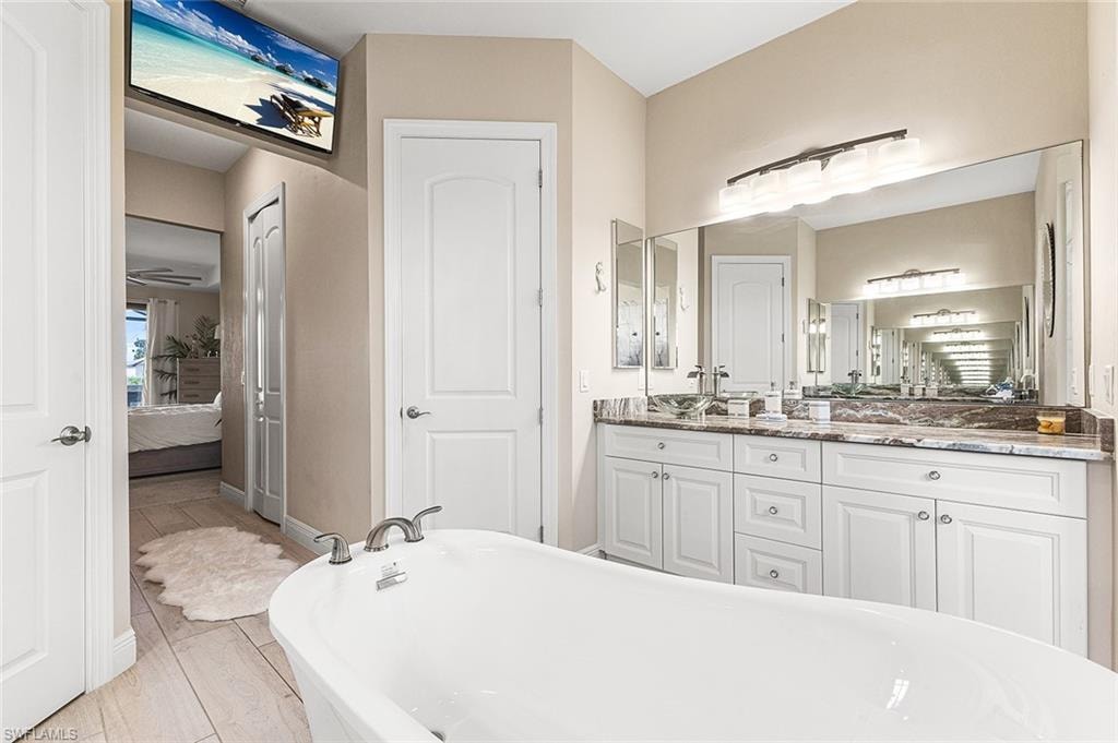 Bathroom featuring a separate standing bathtub, vanity