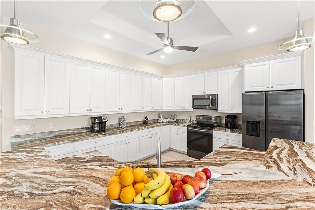 Kitchen with granite counter tops, white cabinets and black appliances