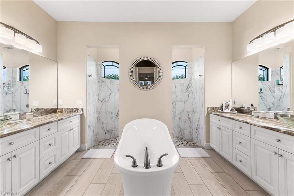 Bathroom with vanity, plenty of natural light, and separate shower and tub