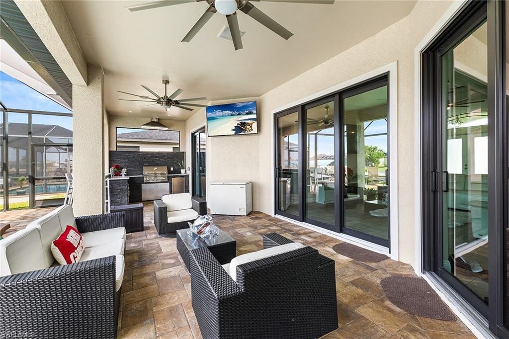 View of featuring impact sliders, outdoor lounge area, outdoor kitchen, and ceiling fan