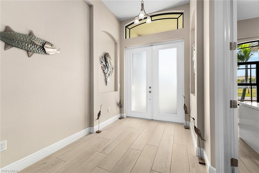 Foyer entrance featuring a chandelier and French doors